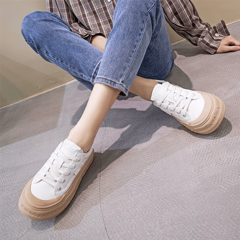 Woman wearing sports women's round toe lace-up sneakers with thick sole, showcasing comfort and style.
